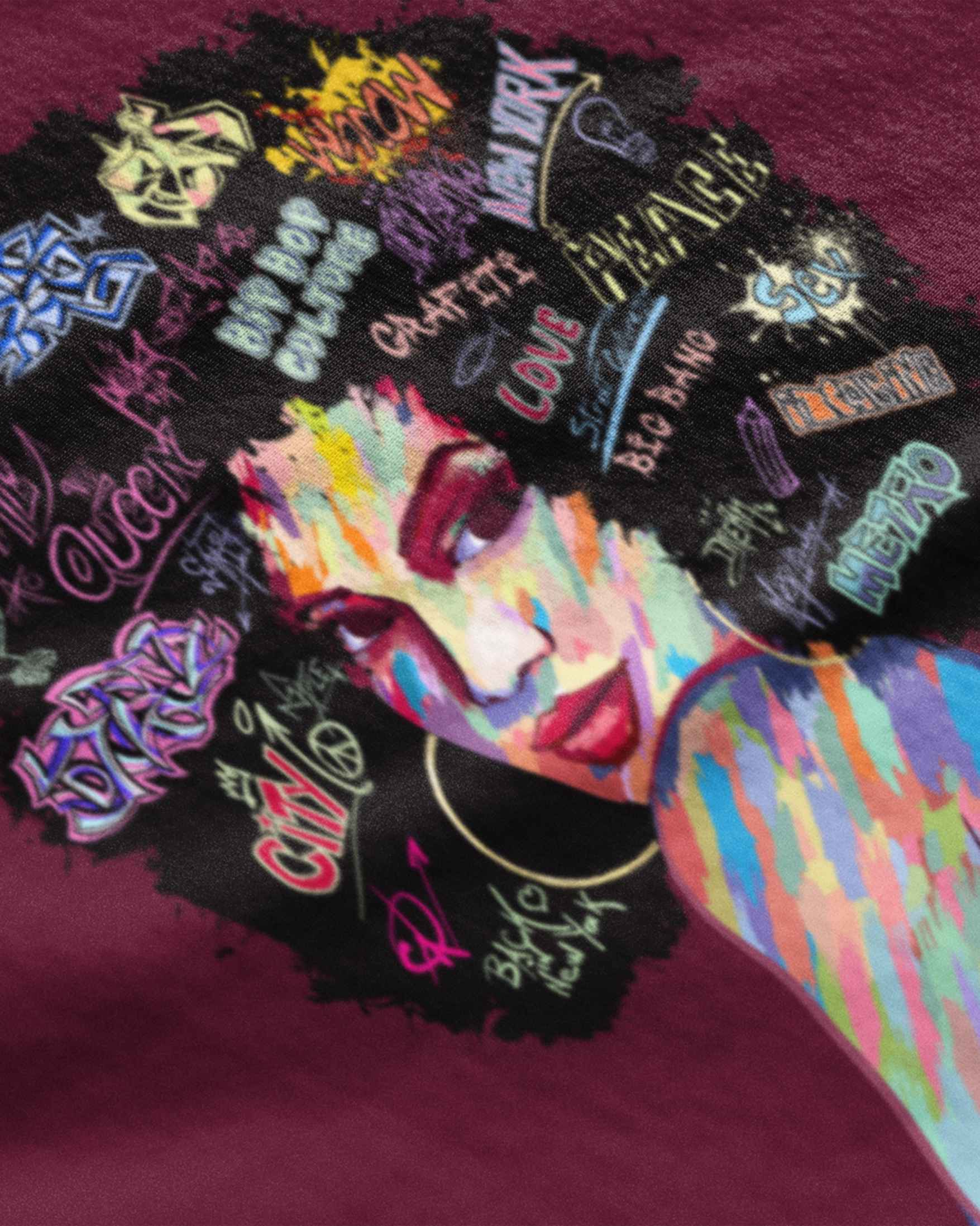 Colorful Afro art graphic t-shirt featuring a vibrant portrait of a woman with graffiti style text in her hair