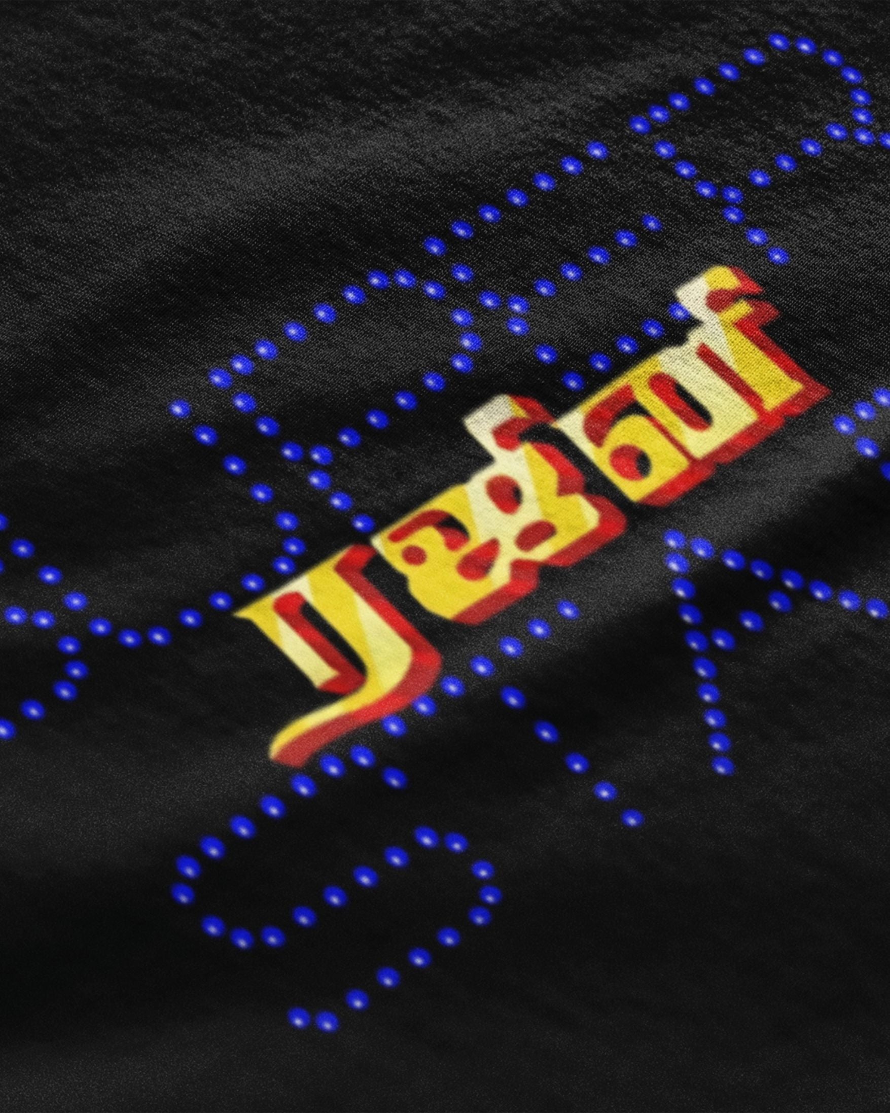 Black graphic tee closeup with colorful Tamil style logo and dotted neon print Rajinikanth streetwear tee India