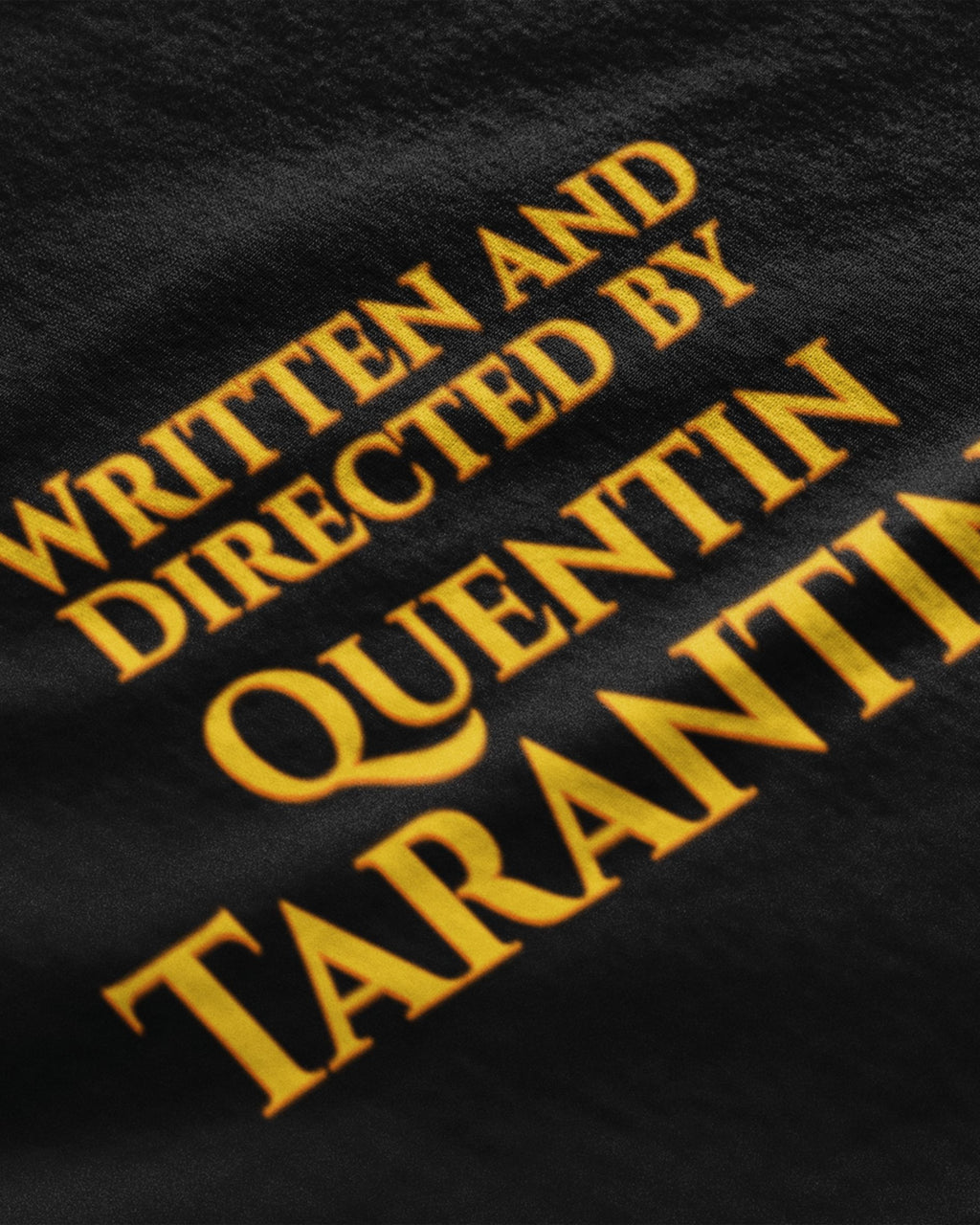 Black Quentin Tarantino graphic t-shirt with yellow text reading Written and Directed by Quentin Tarantino